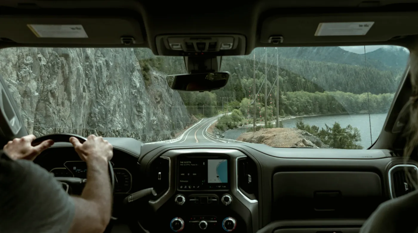 Interior de la cabina de un camión en ruta, con las manos del conductor en el volante: el puesto donde se monta el equipo durante la instalación.